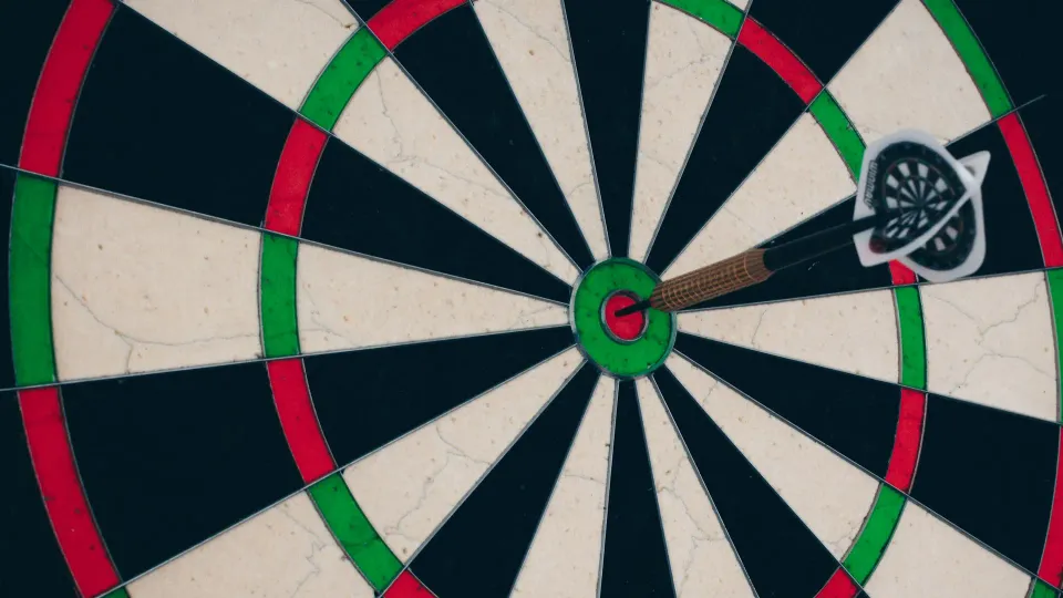 Dartboard with dart sticking in bullseye